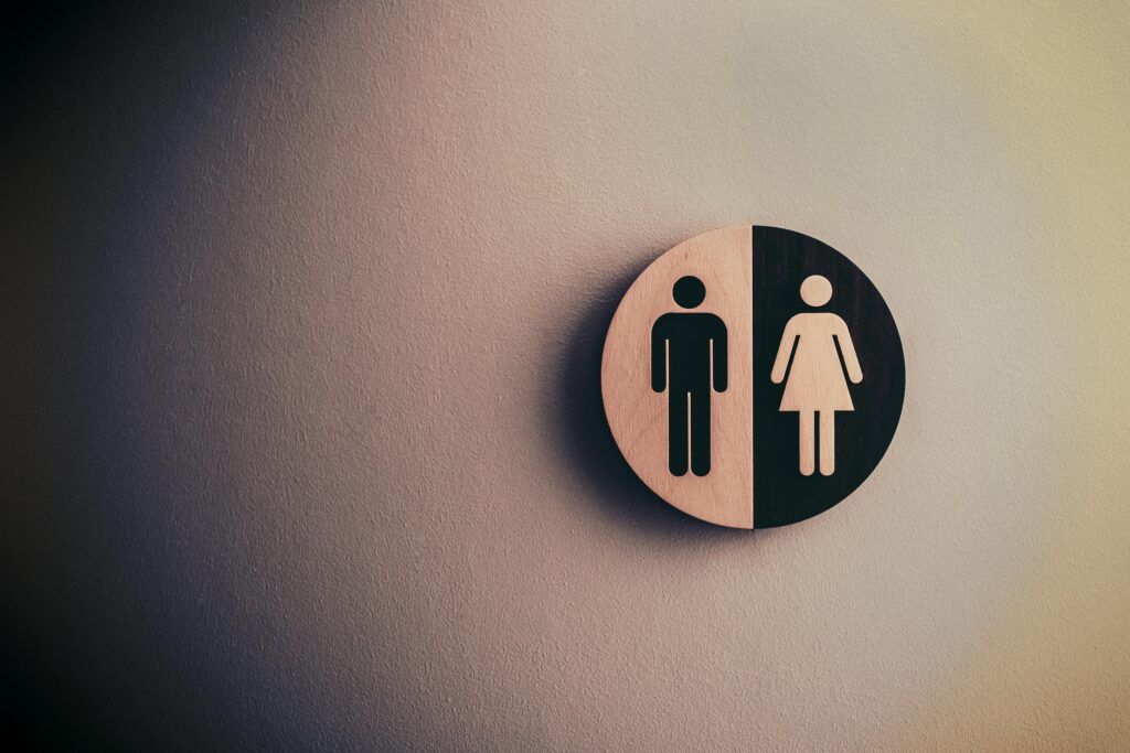 pexels-photo-1722196-1722196 Minimalist gender neutral restroom sign with male and female symbols on textured wall.